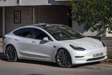 Yana, Türkiye - 05 Şubat 2023: Beyaz Tesla Model 3 sıcak bir günde sokağa park edildi  