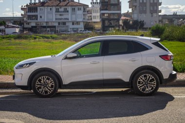 * 23 Ocak 2023: Beyaz Ford Kuga, sıcak bir yaz gününde sokağa park etti.  
