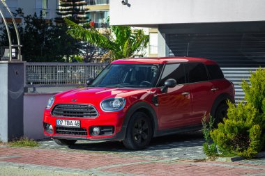 Yan, Türkiye 05 Şubat 2022: Kırmızı Mini Vatandaş sıcak bir yaz gününde bir binanın zeminine, ağaçlara karşı sokağa park etti 