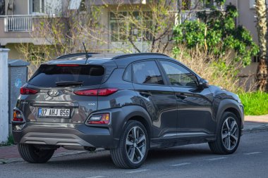 Taraf; Türkiye 05 Şubat 2023: Gri Hyundai Kona, sıcak bir yaz gününde bir binanın arka planına park etti. 