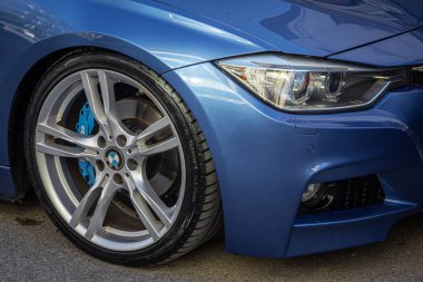 Yan, Türkiye -05 Şubat 2023: Mavi BMW 320, alaşımlı tekerlek ve yakın çekimde yeni lastik. Tekerlek ayarlaması. 