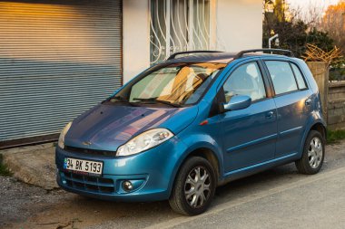 Yana, Türkiye - 23 Ocak 2023: Mavi Chery Kimo sıcak bir yaz gününde sokağa park etti  