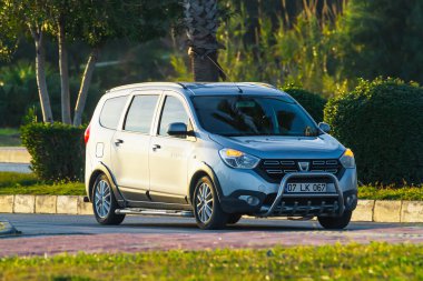 Taraf, Türkiye - 23 Ocak 2023: Dacia Lodgy sıcak bir yaz gününde bir palmiye ağacının zeminine doğru hızla sürüyor 