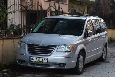 Yana, Türkiye - 29 Ocak 2023: Gümüş Chrysler Voyager sıcak bir günde sokağa park etti 