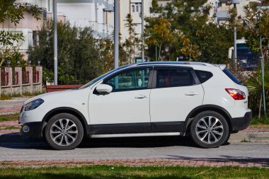 Yan, Türkiye - 11 Şubat 2023: Beyaz Nissan Kashqai, sıcak bir yaz gününde caddeye park etti.