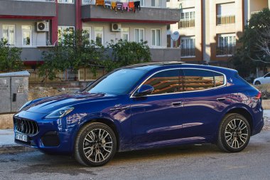 Taraf; Türkiye 11 Şubat 2023: Mavi Maserati Levante bir yaz gününde sokağa park ediyor  