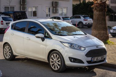 Yana, Türkiye - 11 Şubat 2023: Beyaz Ford Fiesta sıcak bir sonbahar gününde sokağa park edilir 