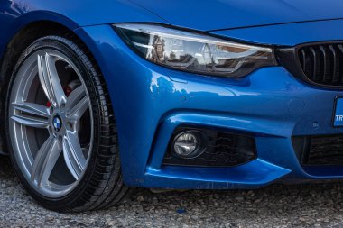 Yana, Türkiye 13 Şubat 2023: Mavi BMW, klasik arabanın ayrıntılı ışığı. araba farları 