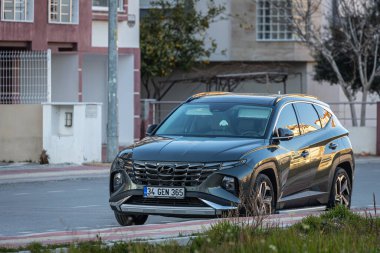 Yana, Türkiye - 13 Şubat 2023: Gri Hyundai Tucson sıcak bir günde sokakta hızlı sürüyor 