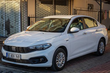 Yan, Türkiye 13 Şubat 2023: Beyaz Fiat Egea sıcak bir günde sokağa park ediyor  