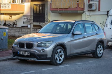 Yana, Türkiye 13 Şubat 2023: Gümüş renkli BMW X-1 kentteki sokağa park edildi  