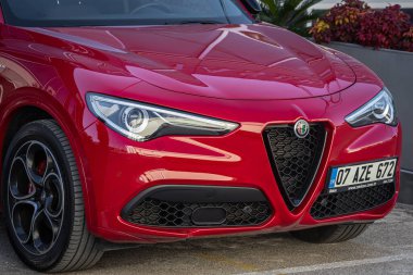 Yana, Türkiye - 18 Şubat 2023: Kırmızı Alfa Romeo Giulia sıcak bir günde caddenin arka planına park etti