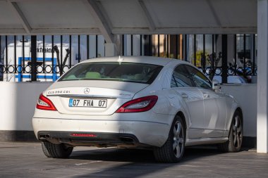 Yan, Türkiye - 18 Şubat 2023: Beyaz Mercedes CLS-sınıfı 350 sıcak bir günde sokağa park edildi 