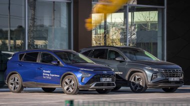 Antalya, Türkiye - 18 Şubat 2023: Araba galerisinin yanındaki yeni arabalar. Mavi Hyundai i30 ve gümüş rengi Hyundai Tucson, sıcak bir günde otosalona karşı sokakta park halindedir. 