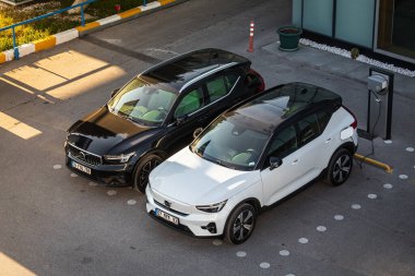 Antalya, Türkiye - 18 Şubat 2023: Otomobil bayiliğinin yanındaki yeni arabalar. Siyah Volvo XC90 ve beyaz Volvo XC40, otosalona karşı sıcak bir günde sokağa park etti 