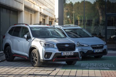 Antalya, Türkiye - 18 Şubat 2023: Araba galerisinin yanındaki yeni arabalar. Silver Subaru Forester, Impreza, Autosalon 'a karşı sıcak bir günde sokağa park etti. 