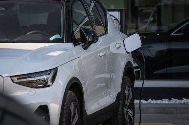 Sokakta modern elektrikli bir arabayı şarj etmek. Eko araba konsepti.