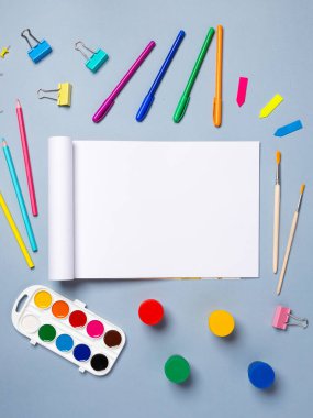 Açık arkaplan üzerinde suluboya, gouache, fırça ve diğer kırtasiye malzemelerinin olduğu boş çizim defterini aç, boşluğu kopyala