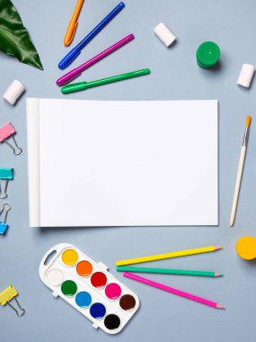 Açık arkaplan üzerinde suluboya, gouache, fırça ve diğer kırtasiye malzemelerinin olduğu boş çizim defterini aç, boşluğu kopyala