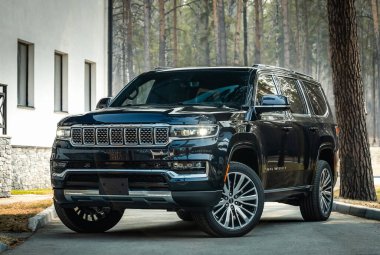 Novosibirsk, Rusya - 25 Nisan 2023: Siyah Jeep Wagoneer, sıcak bir yaz gününde park alanına park etmiş.