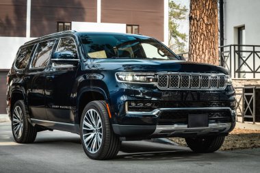 Novosibirsk, Rusya - 25 Nisan 2023: Siyah Jeep Wagoneer, sıcak bir yaz gününde park alanına park etmiş.