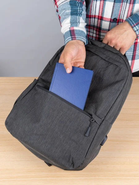 Seorang Pria Dalam Kemeja Kotak Kotak Mengeluarkan Notebook Biru Dari — Stok Foto