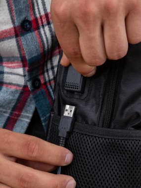 USB konnektörünü siyah bir sırt çantası içinde kapat, çanta 