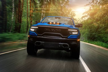  Novosibirsk, Rusya - 27 Temmuz 2023: Mavi Dodge Ram Trx Havok versiyonu, sıcak bir günde bir ormanın arka planına karşı araba sürmek