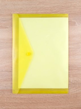 Ofis masasındaki sarı plastik belge dizininin yakın görüntüsü