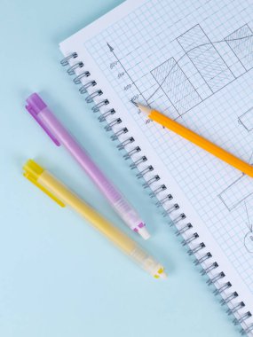 Damalı bir defterin üzerinde duran sarı bir tahta kalem ve silgiyi kapat ve çalışmaya başla.