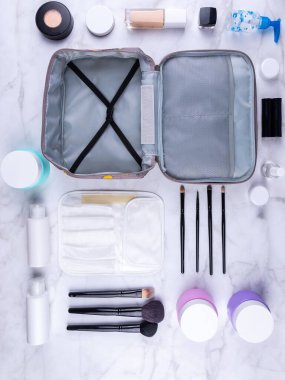 Güzel, gri kozmetik bir çanta ve kadın derisi için gerekli ürünler. Kozmetik ürünler, şampuan, kremler, makyaj fırçaları kozmetik bir çantada güzel bir kadınlar tuvaletinin arka planında.