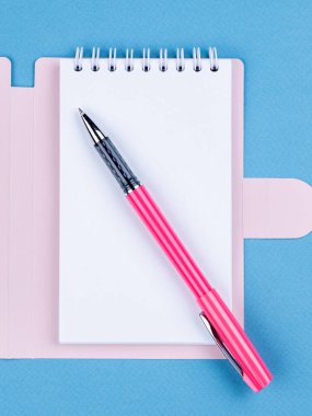 Tasarım konsepti - beyaz sayfalı not defterinin üst görünümü ve maviş için mavi arkaplan üzerine kalem.