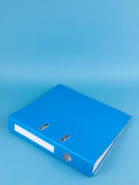 Blue Binder File Folder on blue background, close up