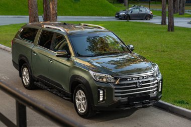 Novosibirsk, Rusya - 29 Ağustos 2023: yeşil SsangYong Rexton Khan SUV ormana park etmiş, ön manzara