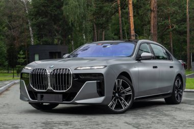Novosibirsk, Rusya - 29 Ağustos 2023: BMW 7 Serisi, 740i, bir ormanın 3 / 4 önü. Başka araba ve insan yok..