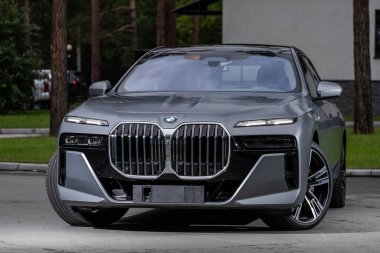Novosibirsk, Rusya - 29 Ağustos 2023: BMW 7 Serisi, 740i, modern mimarinin arka planına karşı ön görüş 