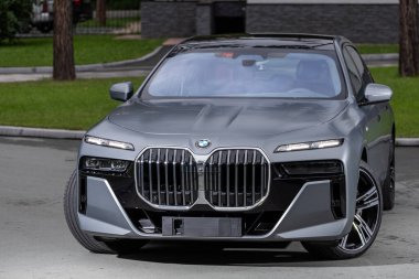 Novosibirsk, Rusya - 29 Ağustos 2023: BMW 7 Serisi, 740i, modern mimarinin arka planına karşı ön görüş 