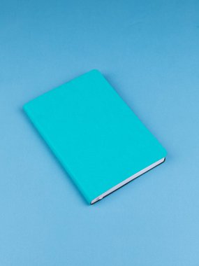 Ahşap masadaki mavi defterin kapağı ders için hazır. Kırtasiye. Okula geri dön.