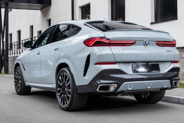  Novosibirsk, Rusya - 11 Ekim 2023: Beyaz BMW X6, sıcak bir sonbahar günü, binanın arka planına karşı sokağa park edilmiş.