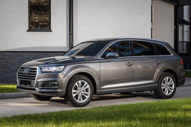 Novosibirsk, Rusya - 11 Ekim 2023: Gri Audi Q7, sıcak bir sonbahar gününde binanın zeminine park etmiş. 