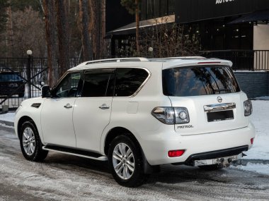 Novosibirsk, Rusya - 10 Kasım 2023: Beyaz Nissan Devriyesi, şehirde park edilmiş SUV, arka görüş