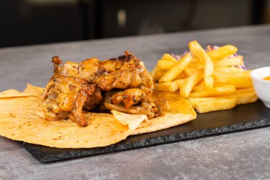 Sebzeli tavuk kebabı, lavaşlı patates kızartması ve sos.