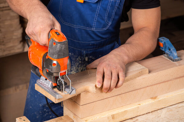 Плотник, использующий мозаику, чтобы резать брусья. 