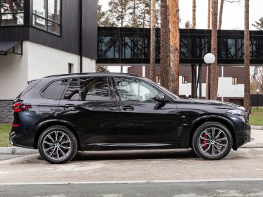 Novosibirsk, Rusya - 16 Kasım 2023: Siyah BMW X5, şehirde park edilmiş SUV, yan görüş