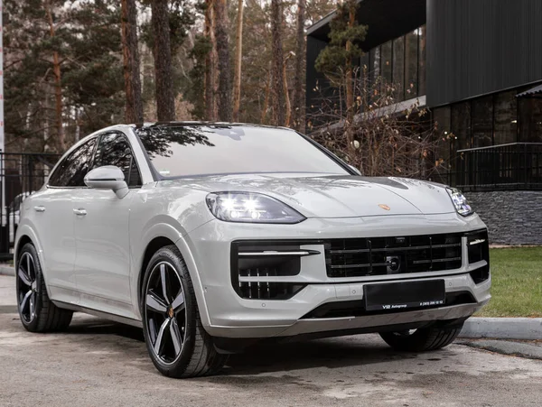 Novosibirsk, Rusya - 16 Kasım 2023: beyaz Porsche Cayenne, şehirde park edilmiş SUV, ön manzara