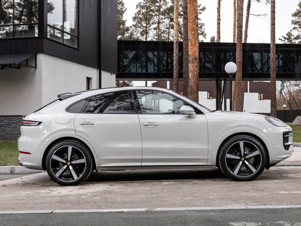 Novosibirsk, Rusya - 16 Kasım 2023: beyaz Porsche Cayenne, şehirde park edilmiş SUV, yan görüş