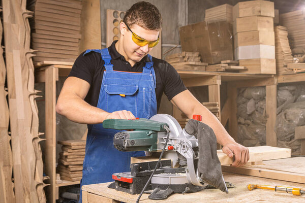 Carpenter cutting oriented strand board with circular saw in workshop. Close-up of carpenter cutting a wooden plank