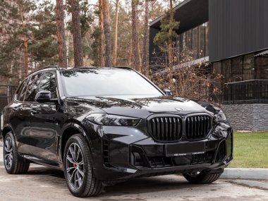 Novosibirsk, Rusya - 16 Kasım 2023: Siyah BMW X5, şehirde park edilmiş cip, ön manzara