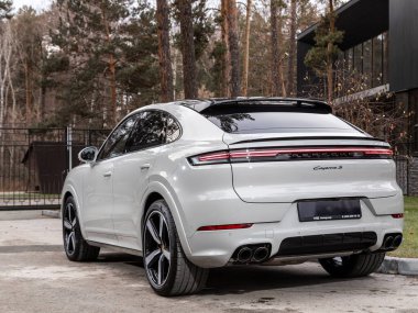 Novosibirsk, Rusya - 16 Kasım 2023: beyaz Porsche Cayenne, şehirde park edilmiş SUV, arka manzara