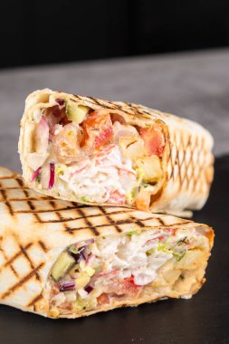 Taze hazırlanmış yengeç çubukları shawarma, sos ve sebzeler tahtanın üzerinde.